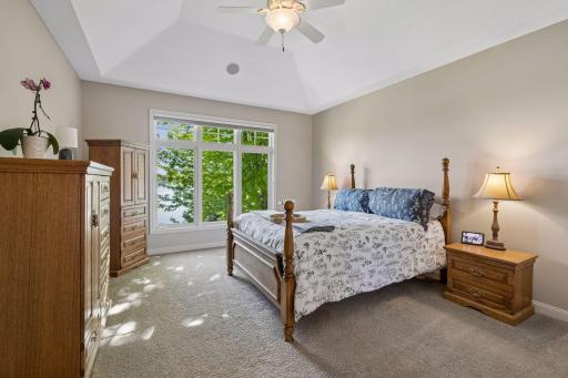 The main-level primary suite is positioned for both privacy and perspective, with tranquil lake views
