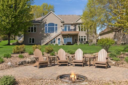 Lakeside firepit patio with space for seating, offering a welcoming view back toward the homeâs exterior