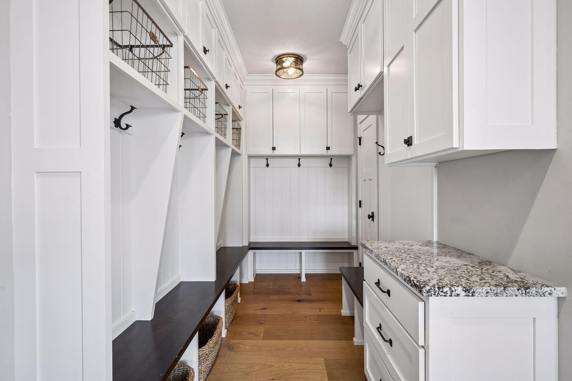 A thoughtfully designed mudroom features a built-in boot bench, custom lockers, and ample storage, offering the perfect blend of organization and convenience.
