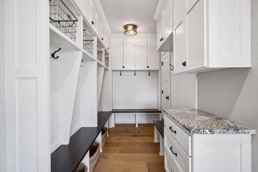 A thoughtfully designed mudroom features a built-in boot bench, custom lockers, and ample storage, offering the perfect blend of organization and convenience.