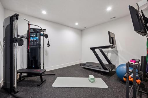 Lower level room currently being used as a home gym.