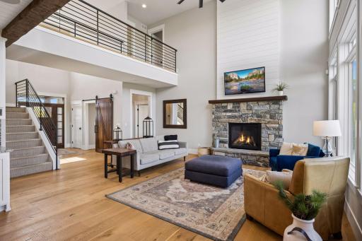 The living room features 2-story ceilings and a stone gas fireplace.