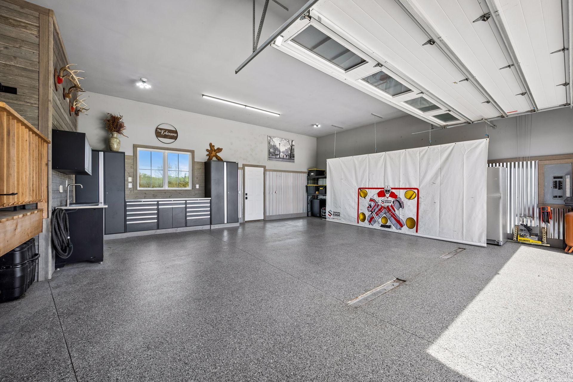 The garage and complete with heated epoxy floors, in floor drains, and custom cabinets.
