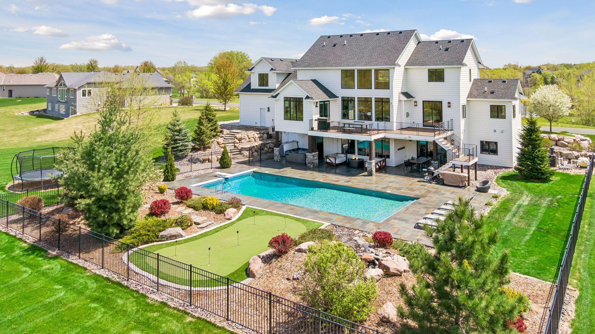 Your own private resort-style retreat featuring an in-ground pool, hot tub, multiple covered outdoor living spaces, and a putting green!