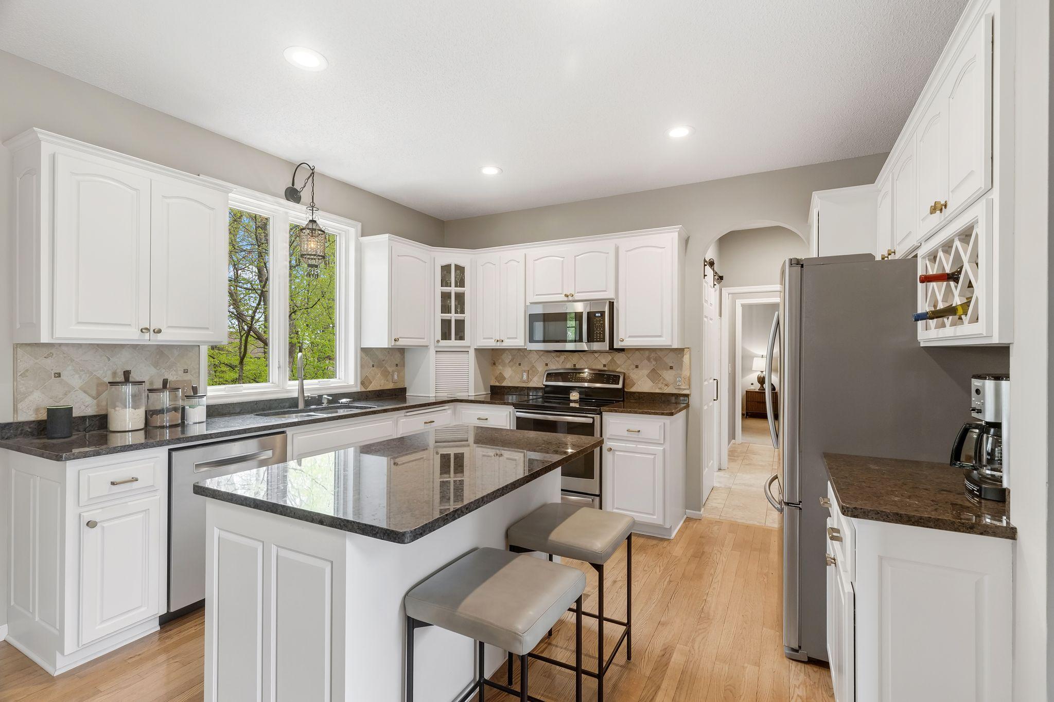 Kitchen features stainless appliances including an induction range
