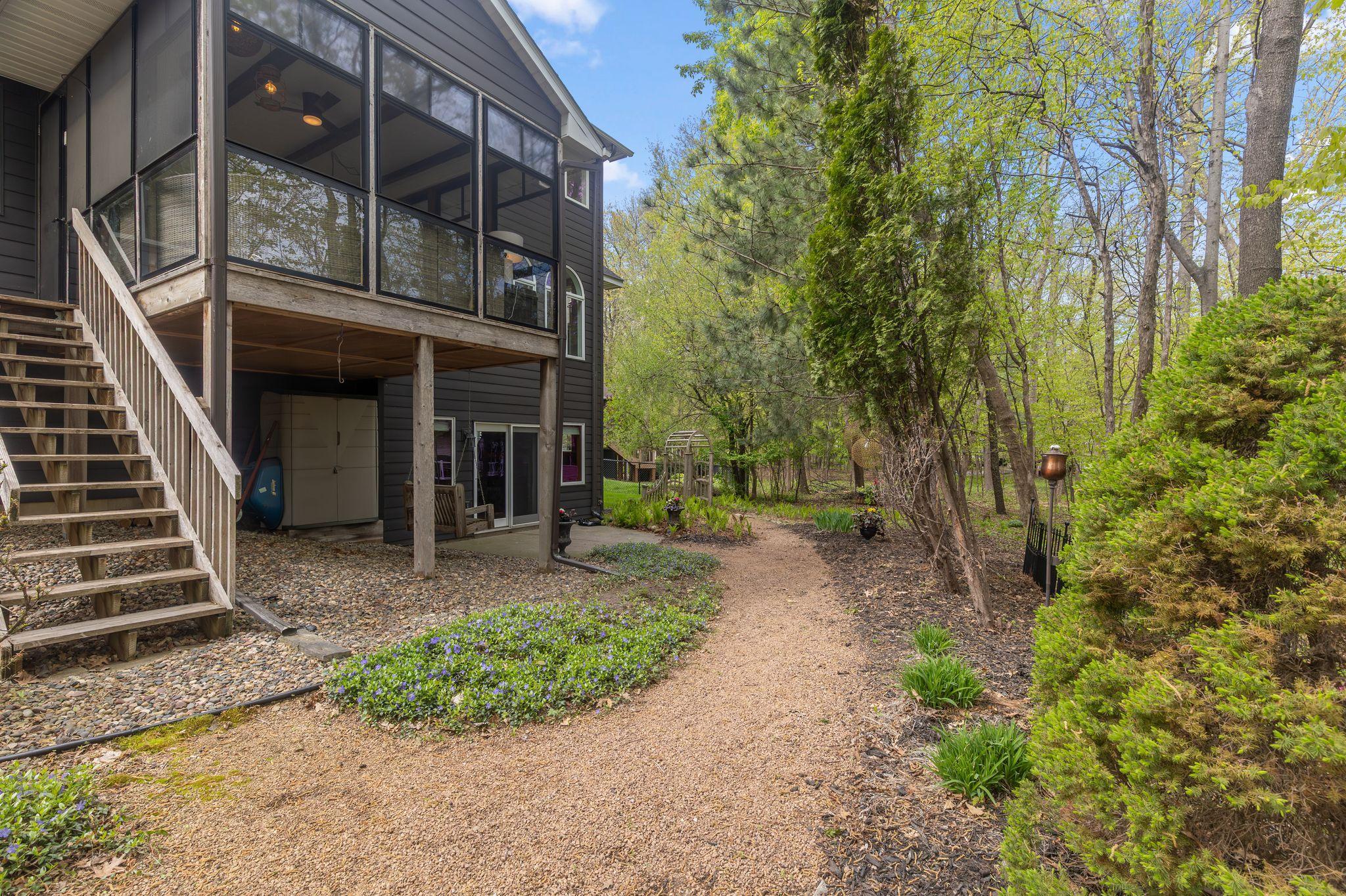 Landscaped path through tree-lined backyard
