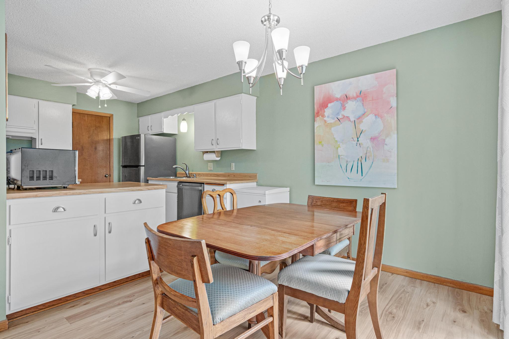 The dining room has updated vinyl flooring and an updated light fixture. The open concept kitchen has great counter space for food prep.