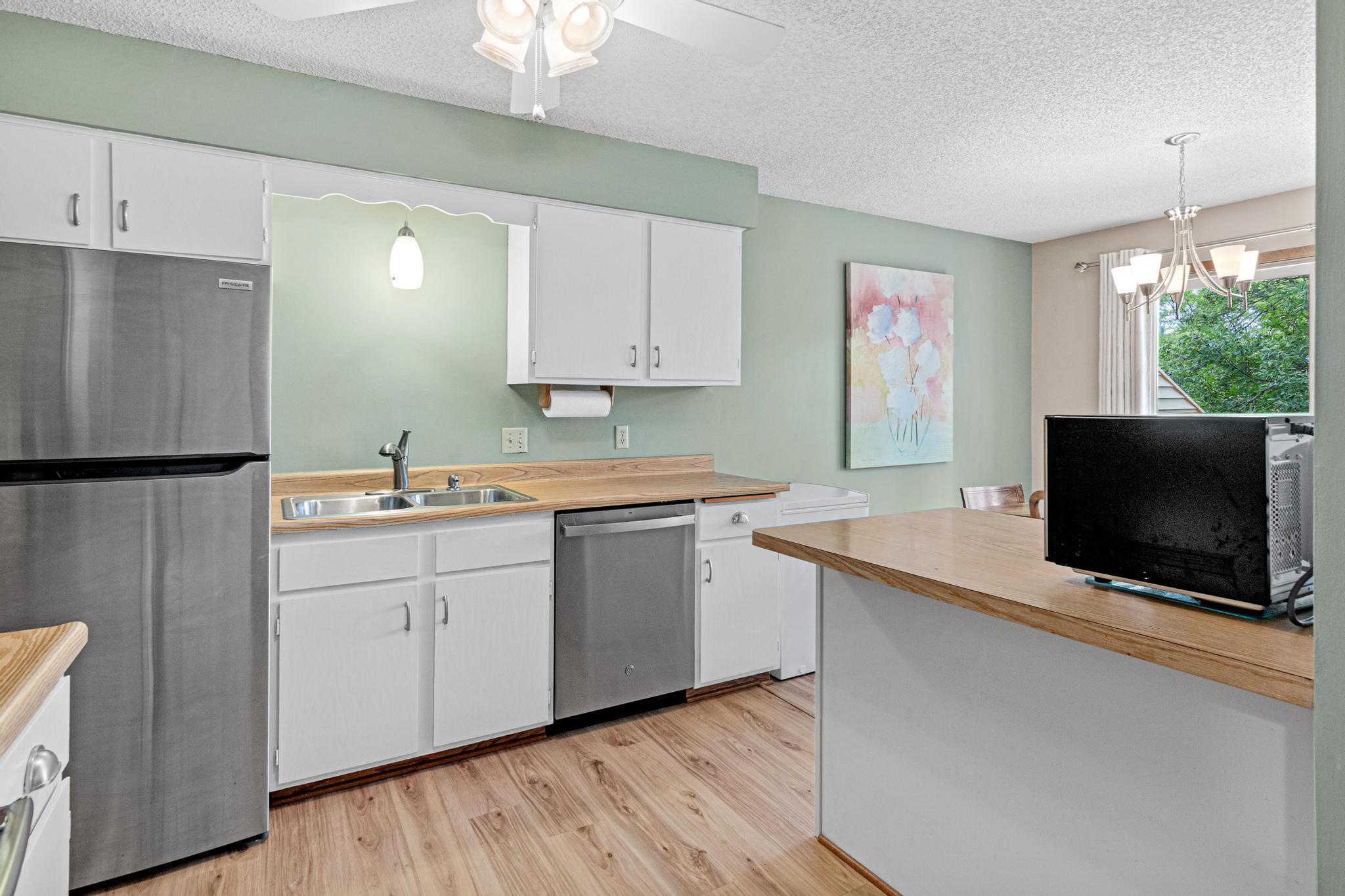 The kitchen is fresh and bright with tons of storage! The crisp white cabinets are topped with a faux butcher block counter and have updated brushed satin pulls.