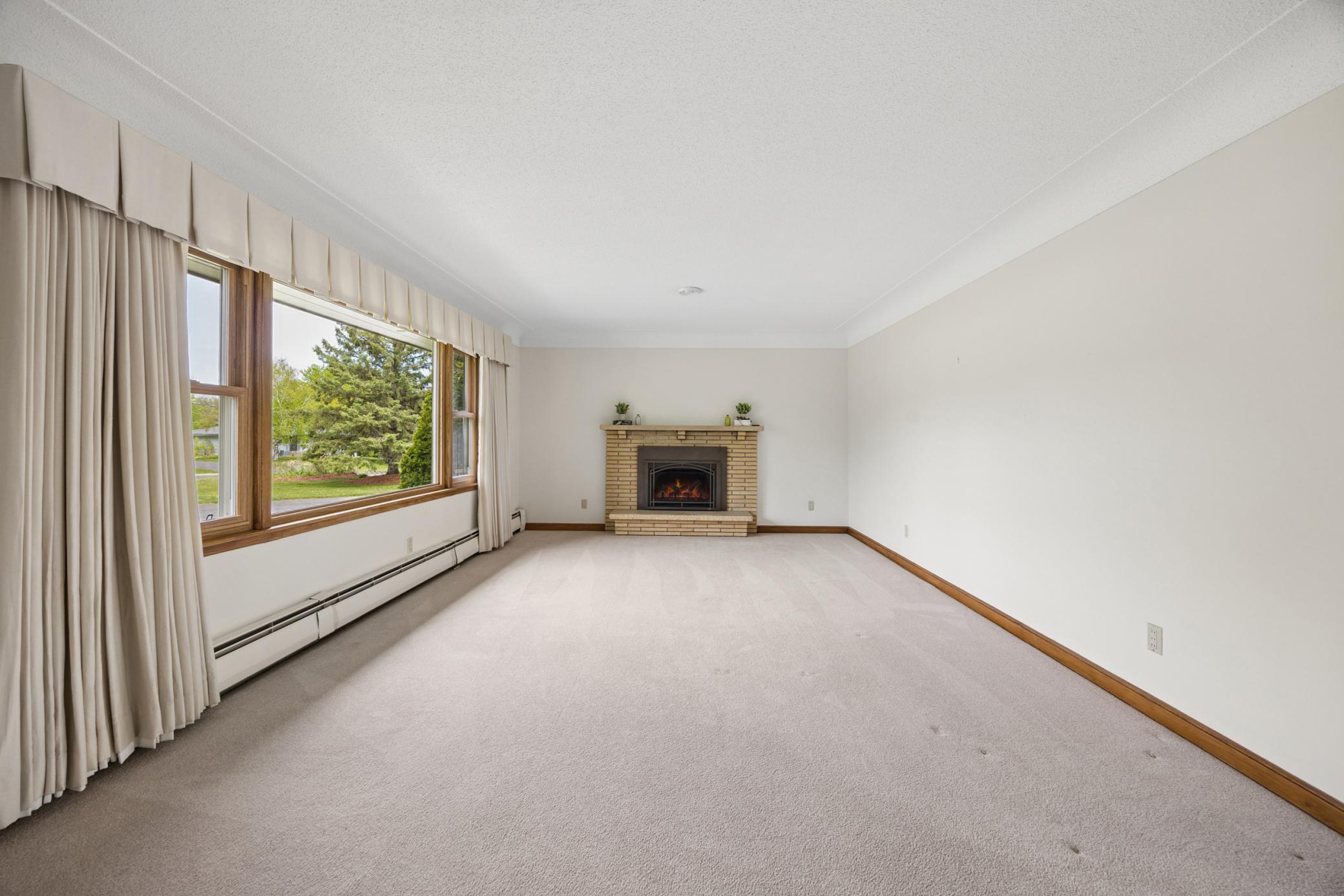 Brick surround fire place and soft carpeting add to the ambiance of this room.