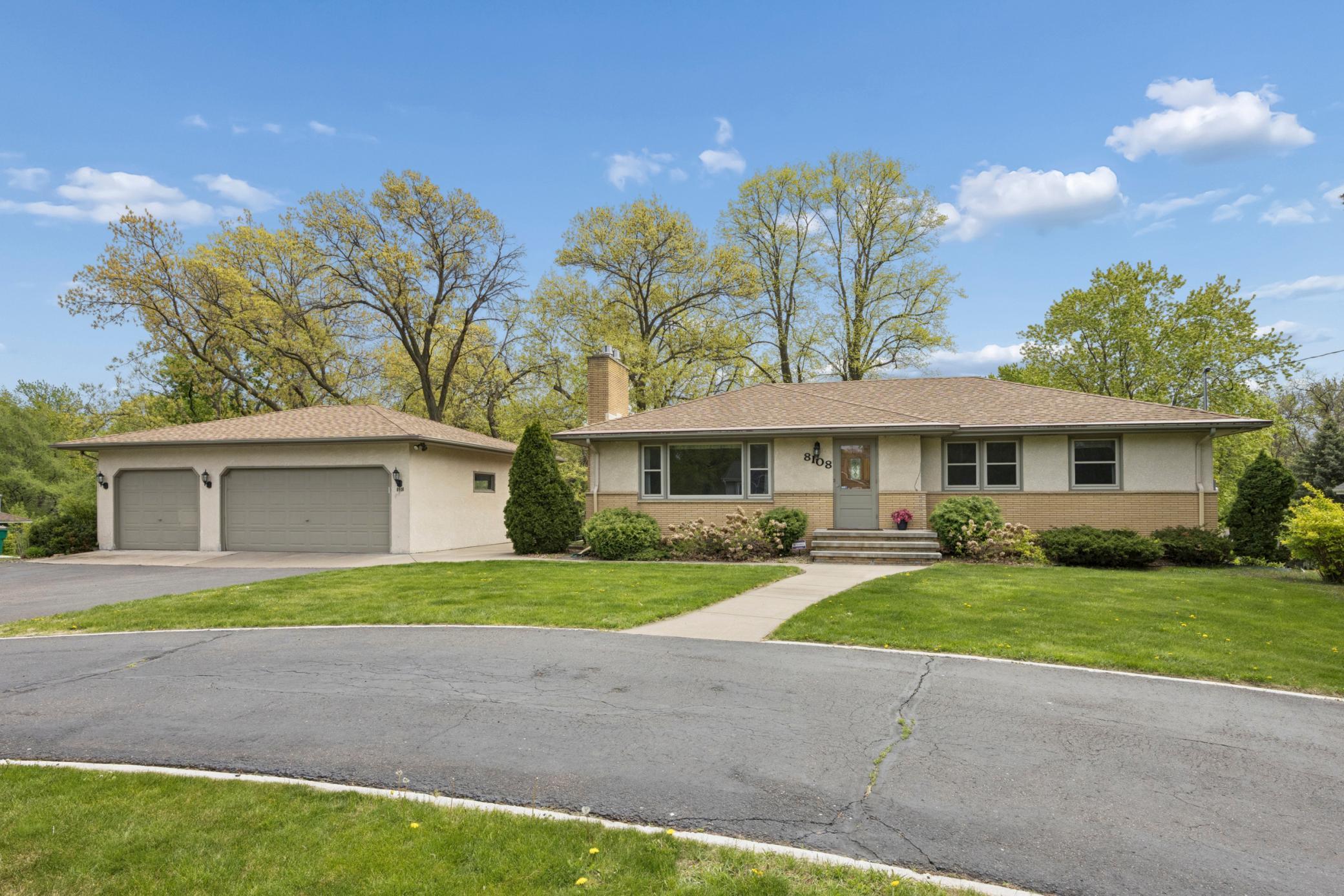Beautifully landscaped grounds with towering trees, open lawn space, and endless outdoor potential