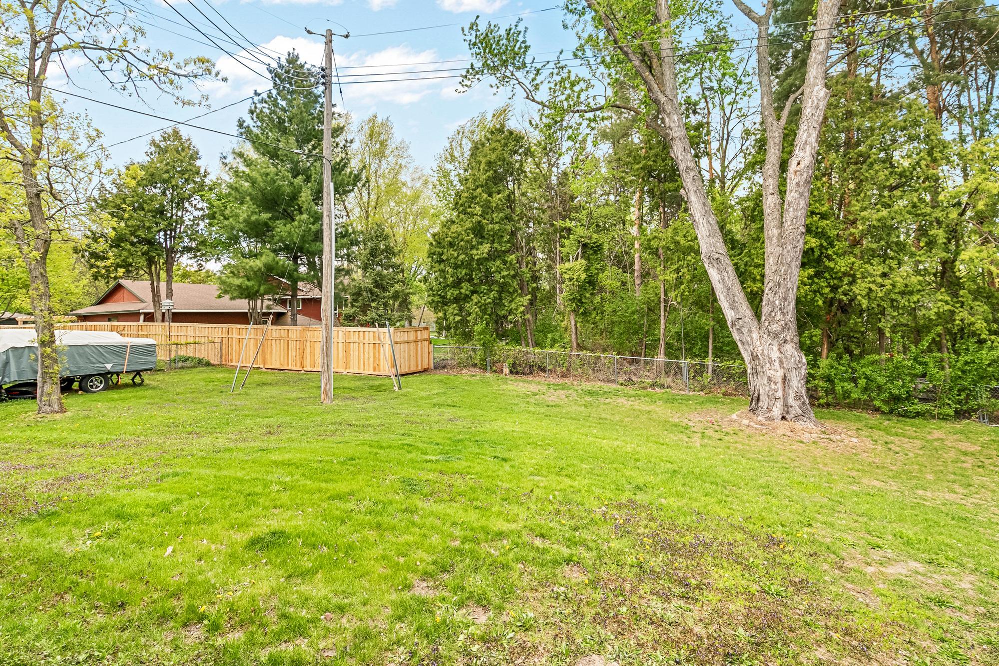 The property line includes the wooded area behind the chainlink fence.