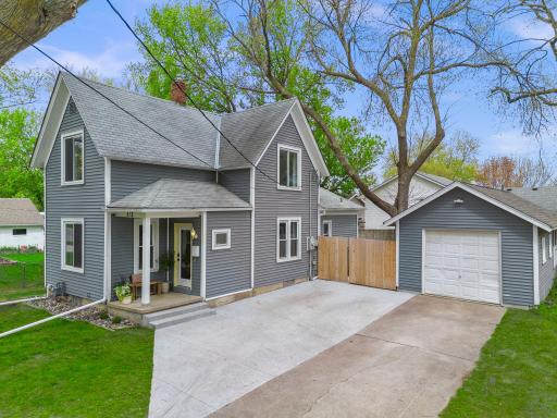 Mature trees surround the property, creating shade and privacy, while the detached one-car garage and double-wide driveway provide excellent parking flexibility and additional storage.