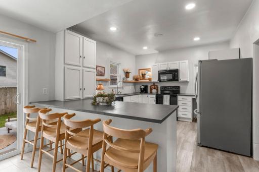 Large peninsula with breakfast bar seating, perfect for casual dining, meal prep, or gathering with guests.