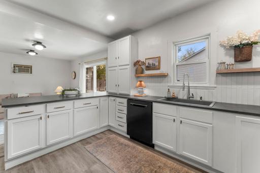 The beautiful kitchen, fully updated in 2023, combines style and functionality with sleek tile backsplash, generous cabinetry, and cabinet pantry storage.