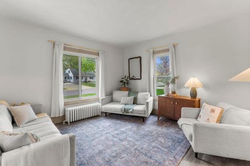 The light-filled living room features large windows with peaceful yard views.
