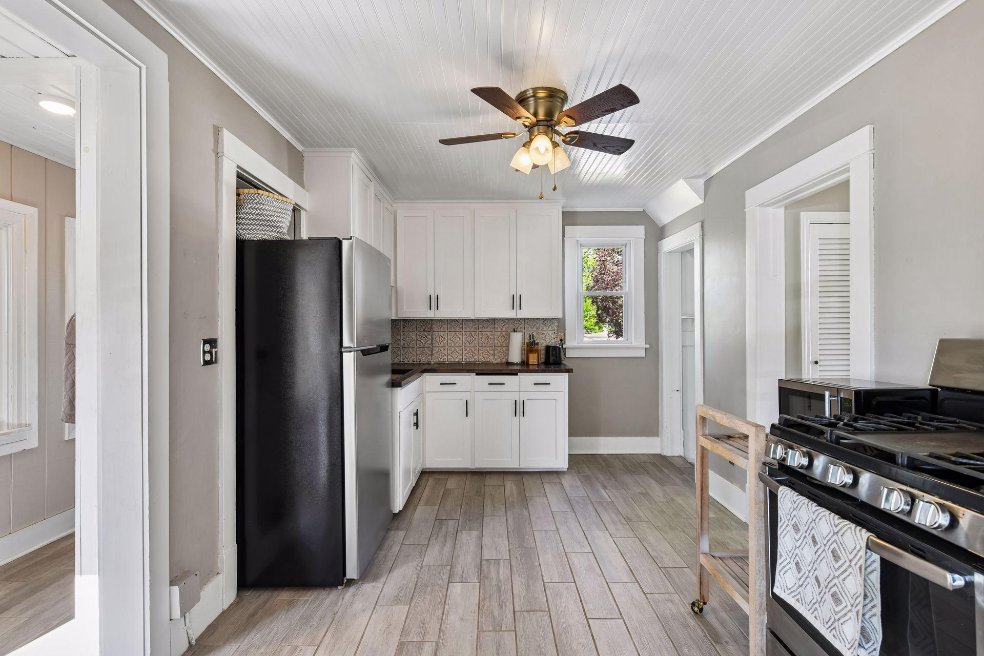 Refaced cabinets, updated backsplash, butcher block counter tops, wood like tile flooring