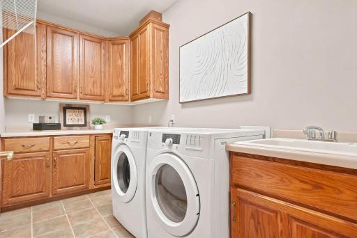 Main-floor laundry room offers a sink and storage space.