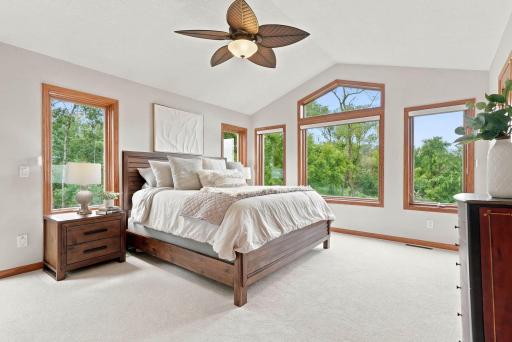 Enjoy a spa like primary suite with vaulted ceilings overlooking the pond.