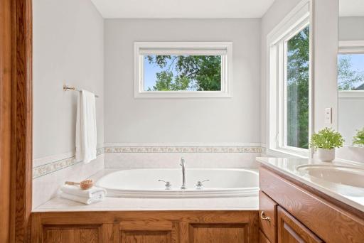 Soaking tub overlooks mature trees and acreage.