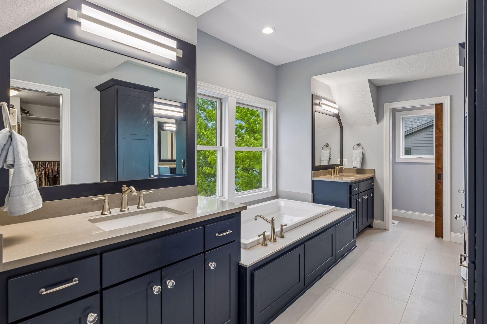 En-suite bath offering heated floors, dual vanities + separate make-up counter, jetted tub, walk-in tile shower.