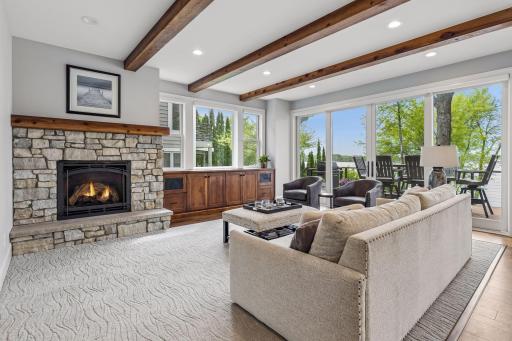 The inviting living room features a gas fireplace with stacked stone surround,