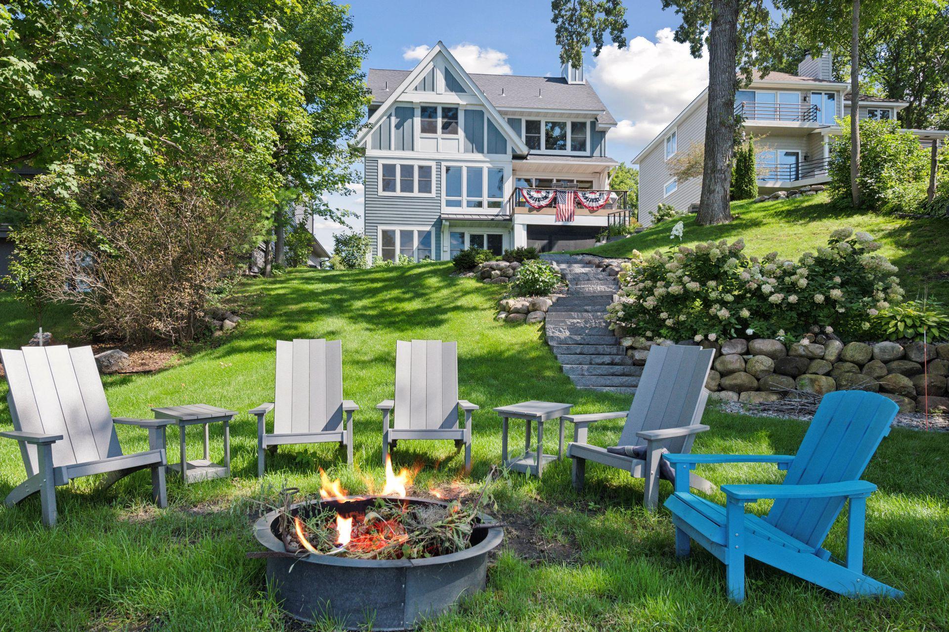Stone steps and manicured lawn lead down to the riprap shoreline.