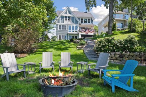 Stone steps and manicured lawn lead down to the riprap shoreline.