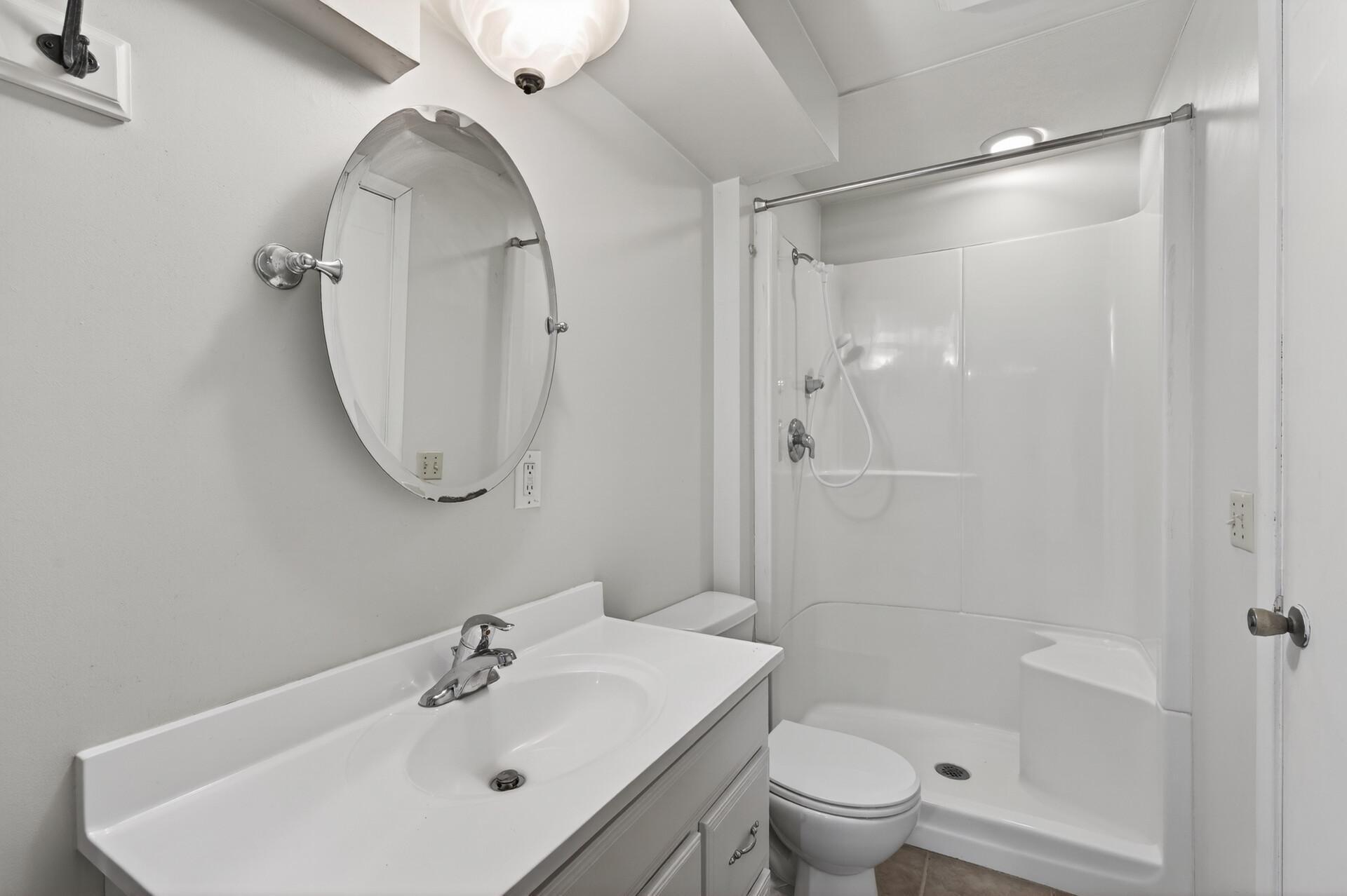 Lower level bathroom is ensuite to bedroom and includes newer vanity, shower, and flooring.