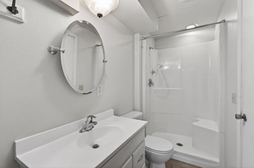 Lower level bathroom is ensuite to bedroom and includes newer vanity, shower, and flooring.