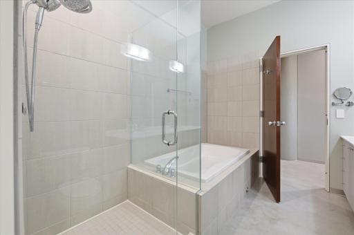 Contemporary bathroom with glass shower doors and a full bathtub for comfort and style.