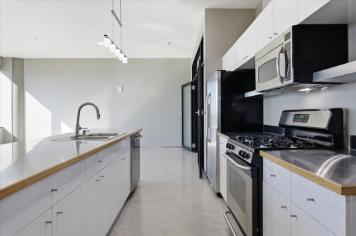 Sleek stainless steel countertops highlight the kitchenâs clean lines and contemporary style.