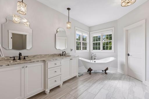A true owner's sanctuary, this elegant bath offers a freestanding soaking tub, luxury walk-in tile shower, private stool room, and generous walk-in closet. Thoughtfully designed to elevate daily routines into moments of indulgence.