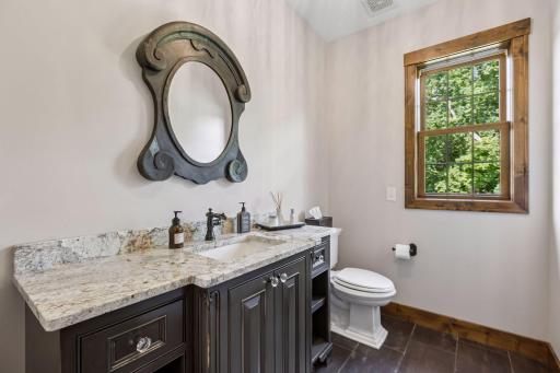 Thoughtfully tucked off the back entry, this charming powder bath welcomes family and guests with rich custom cabinetry, beautiful stone surfaces, and warm natural light. A perfect blend of everyday comfort, convenience, and timeless elegance.
