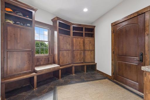 A must-have drop zone designed to simplify daily life. Custom knotty alder cubbies, built-in bench seating, and durable tile floors create the perfect landing space for coats, shoes, backpacks, and all of life's essentials.