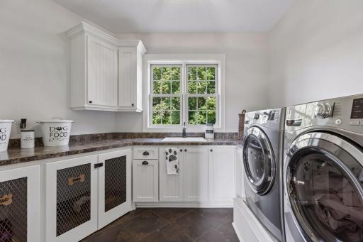 More than a laundry room, thoughtfully designed family hub simplifies daily life w/custom cabinetry, abundant workspace, and a built-in pet retreat. A beautiful space where organization, convenience, and care for furry family members come together.