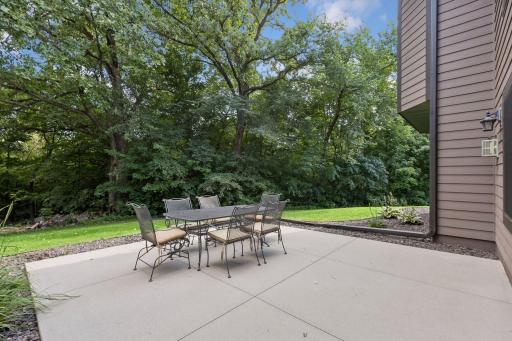 Enjoy peaceful outdoor living on the expansive patio, nestled against a backdrop of mature trees and lush green space. An ideal retreat for entertaining or unwinding in complete privacy.
