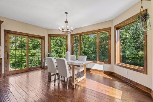Framed by walls of windows and serene wooded views, this inviting dining space is where everyday meals become cherished memories. Gather with family and friends, share stories, and enjoy the beauty and privacy of nature year-round.