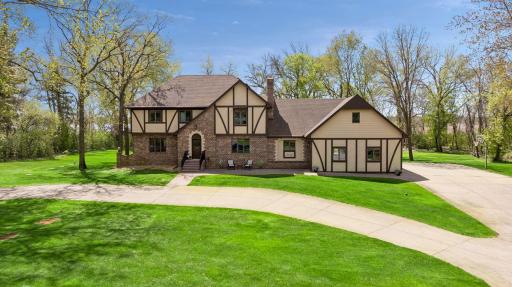 Peaceful lakefront living meets timeless Tudor-inspired architecture on over 4 private wooded acres with coveted southern exposure.