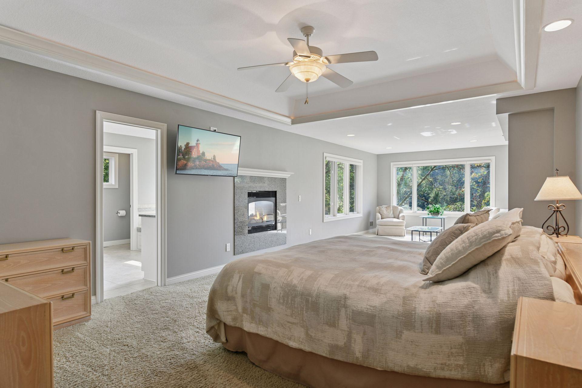 The primary suite has a spa-like bathroom featuring a jacuzzi tub, tiled walk-in shower, heated floors, and extra-large walk-in closet, double sided fireplace that can be viewed from bathroom and bedroom, and a sitting area overlooking wetland/marsh.