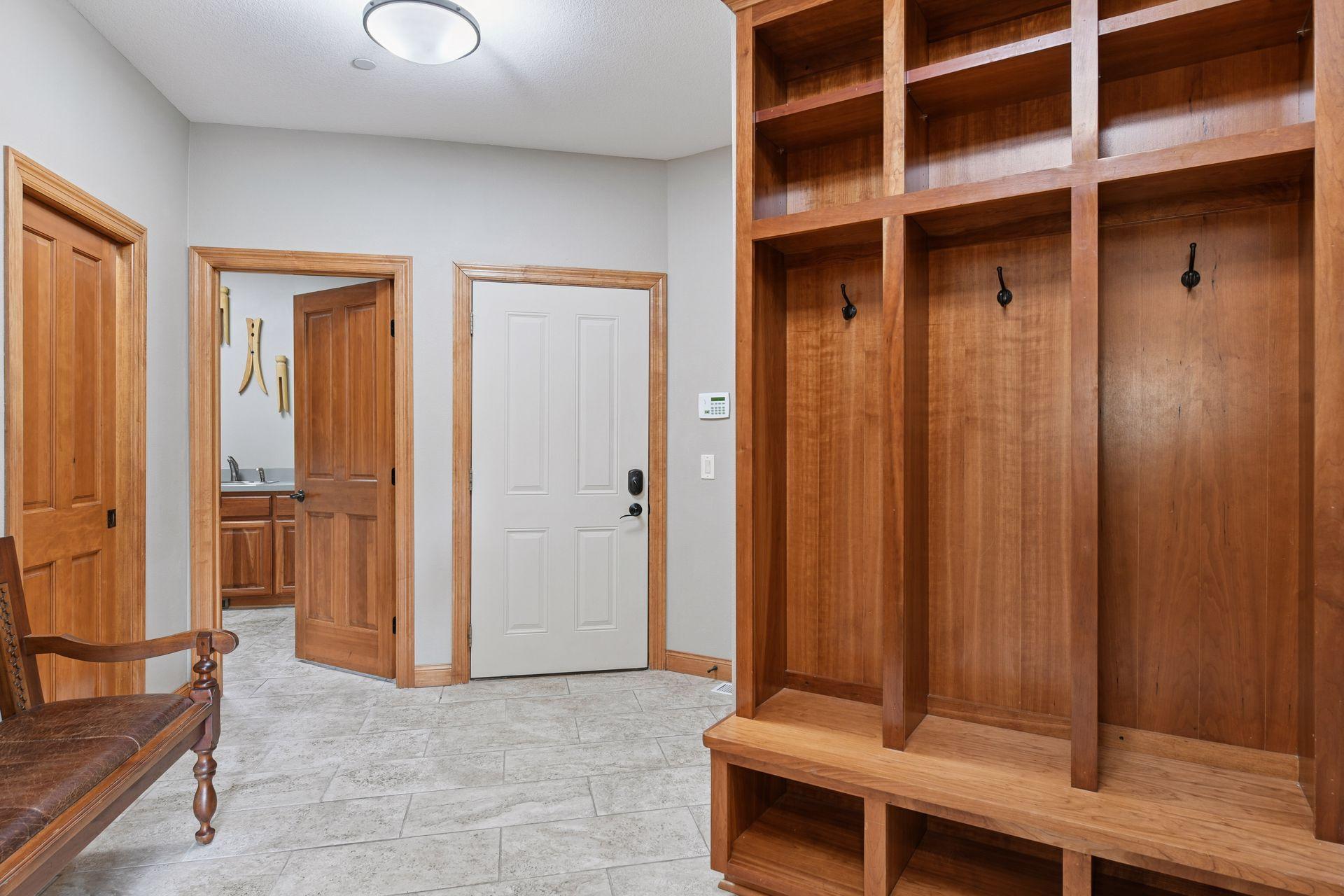 Rear entrance foyer has a tiled floor with 3 built-in lockers, large walk-in closet, laundry room, pantry, and half bathroom.