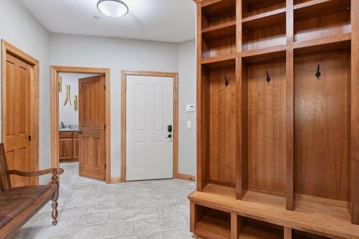 Rear entrance foyer has a tiled floor with 3 built-in lockers, large walk-in closet, laundry room, pantry, and half bathroom.