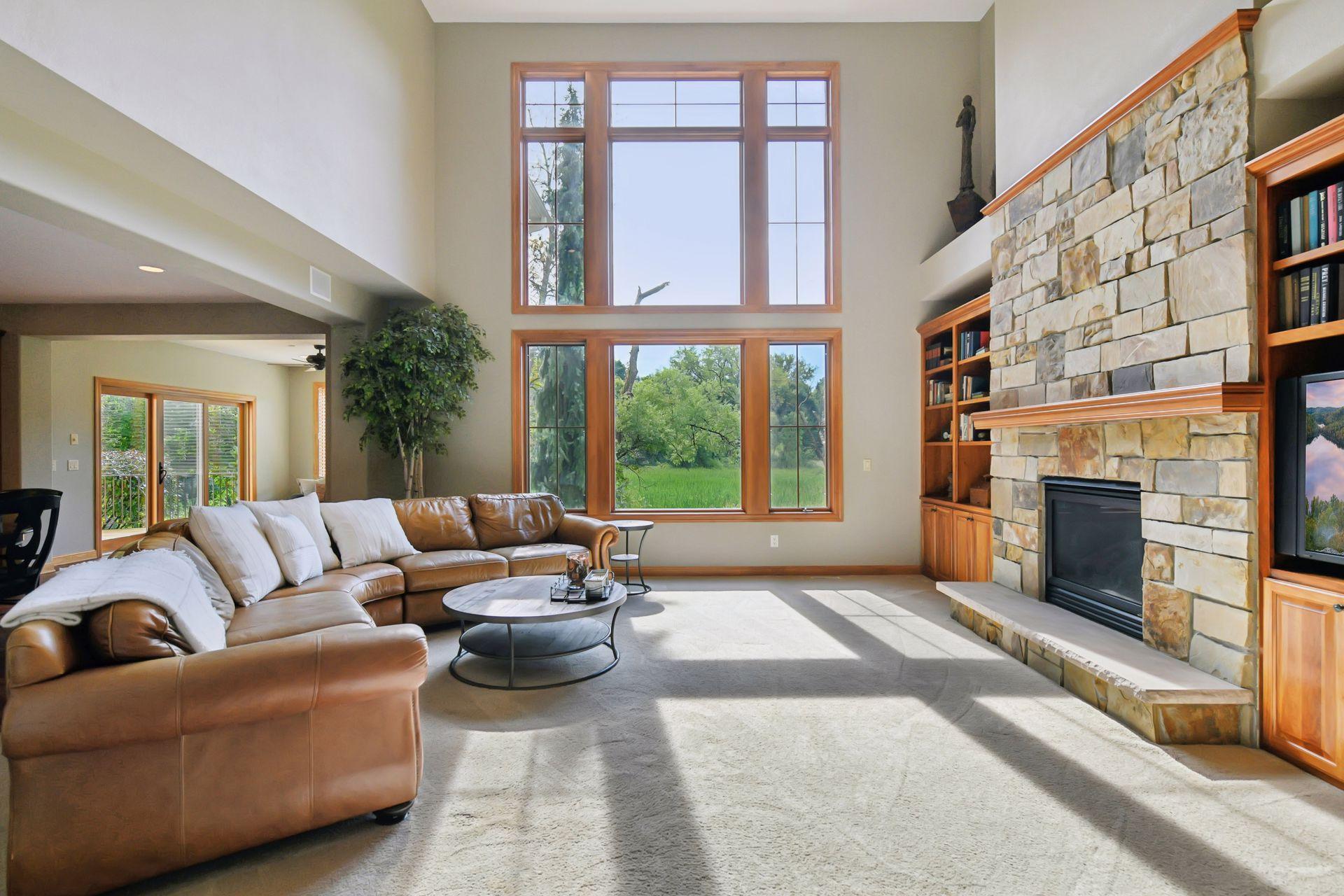 Family room has built in cherry bookcases, stone encased gas fireplace, and large 2 story picture windows for lots of natural light and overlooking wetland/marsh