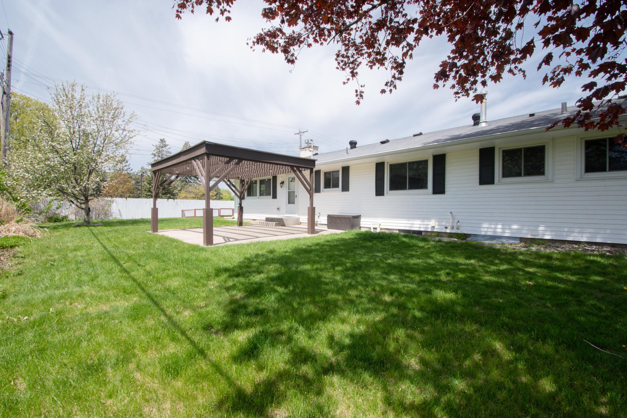 Large concrete patio with pergola.