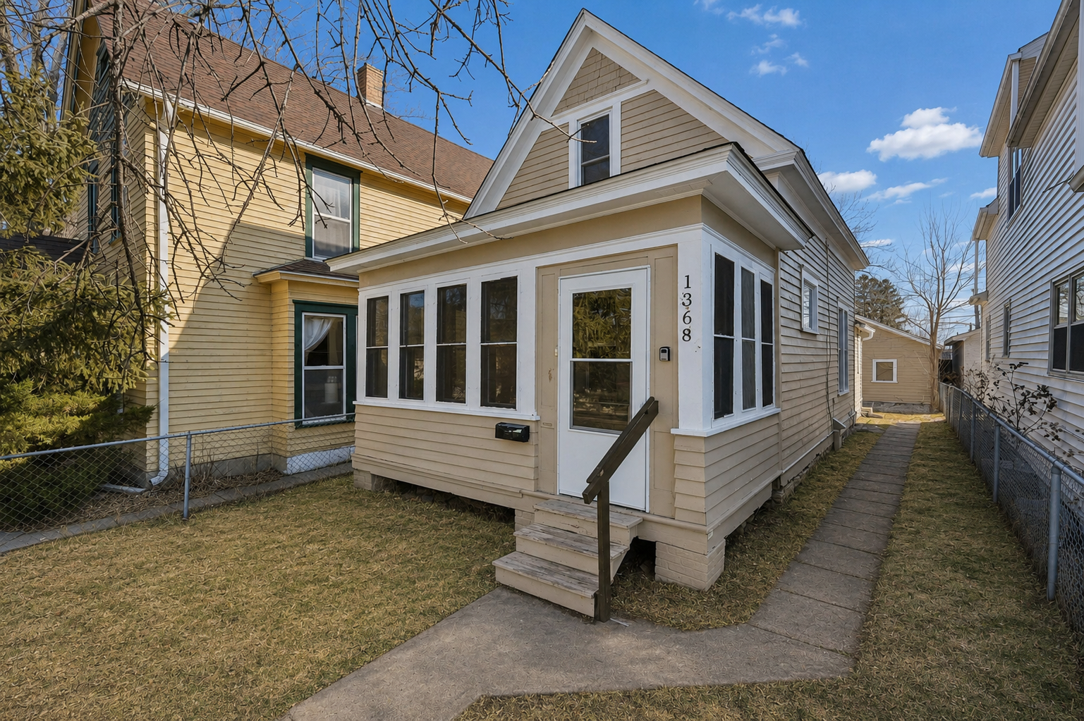 Charming 1½-story home with welcoming enclosed front porch and fully fenced front yard.