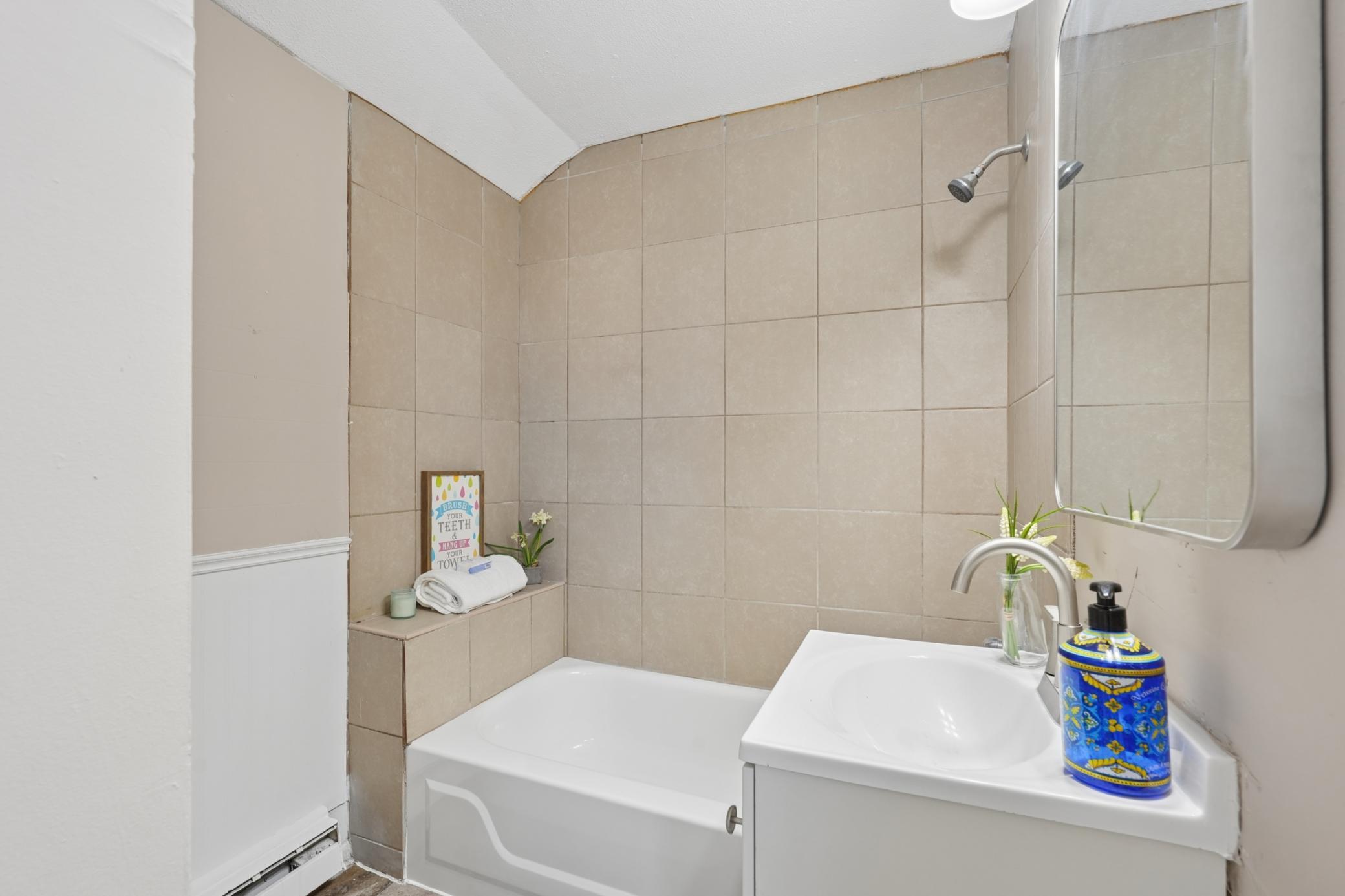 Full bathroom with tiled surround and built-in shower niche.