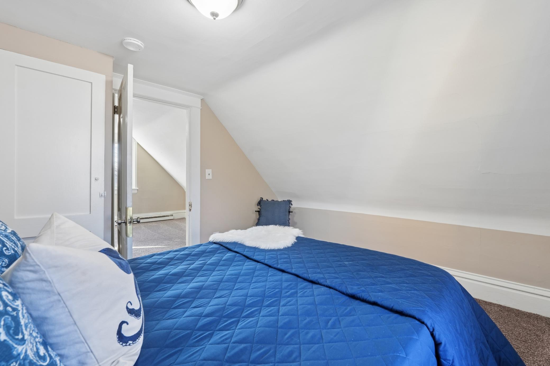 Upper-level room with charming architectural angles and neutral finishes.