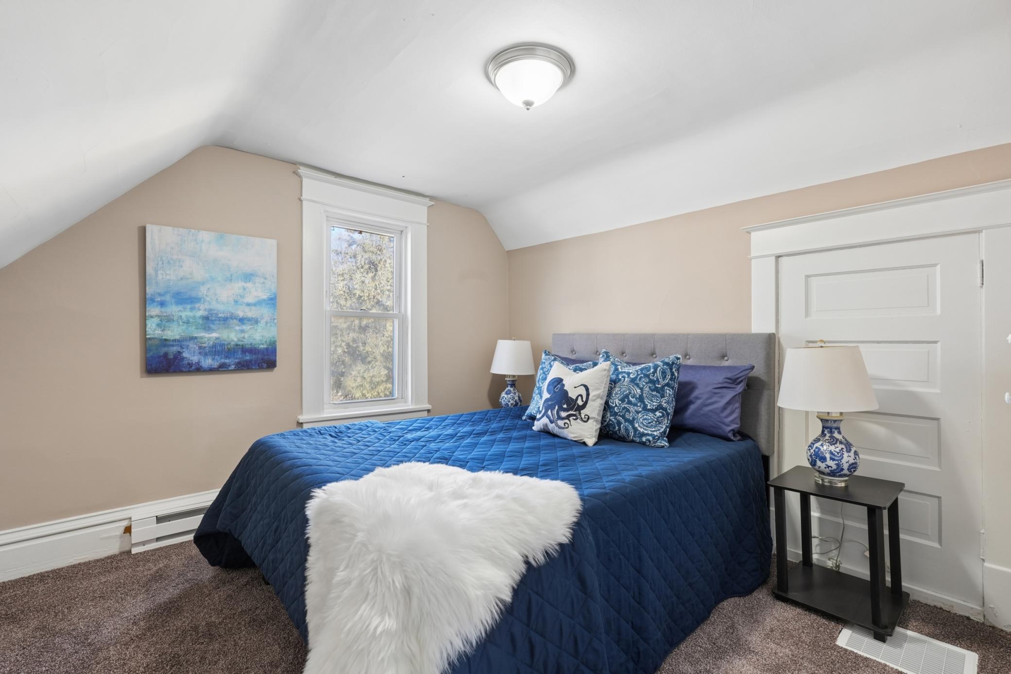 Upper-level bedroom with fresh carpet and cozy dormer ceiling lines.
