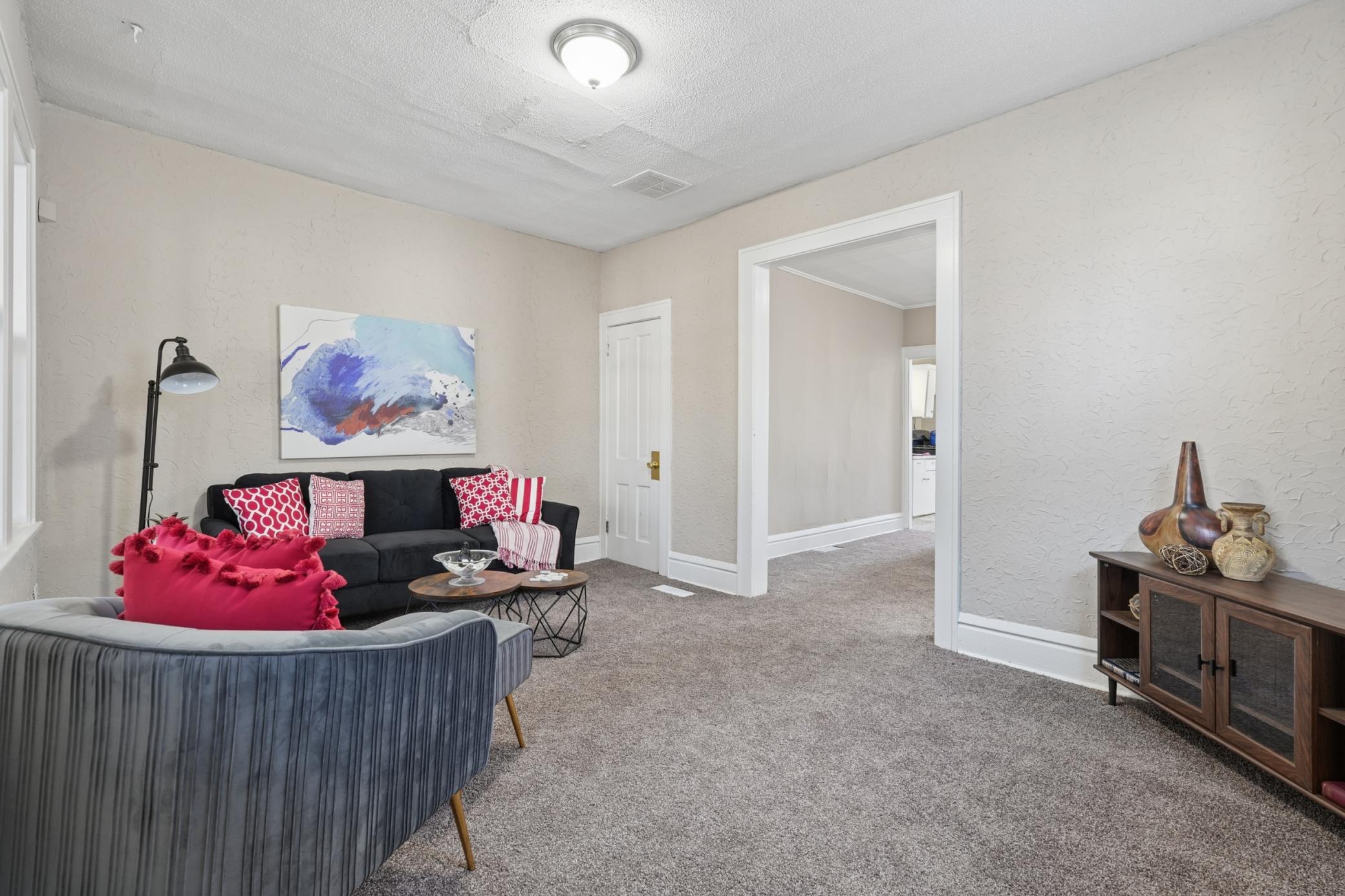 Alternate view of the living room showcasing natural light and open flow to adjoining spaces.