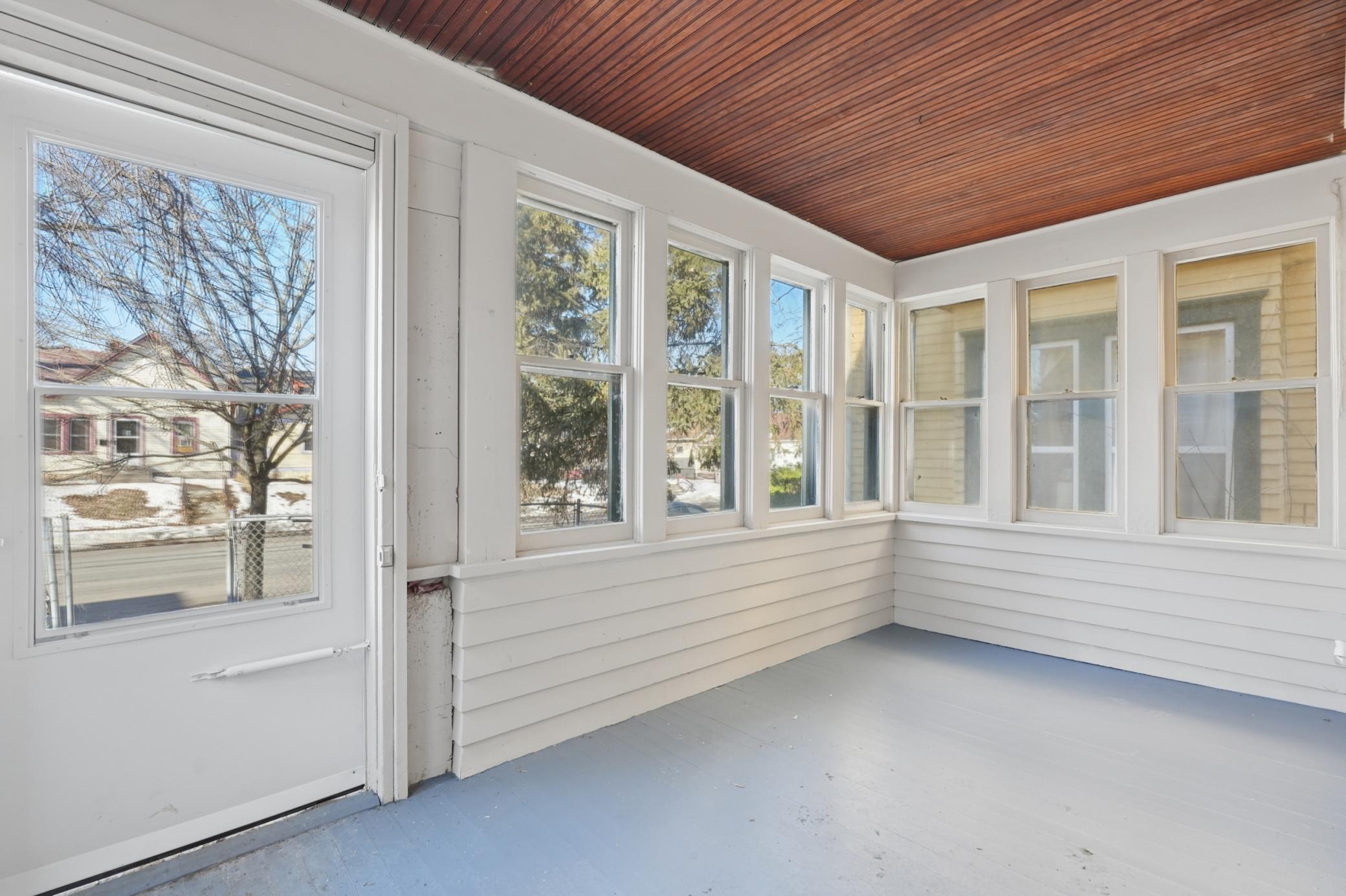 Bright and airy enclosed front porch — perfect for a sunny sitting area or mudroom space.