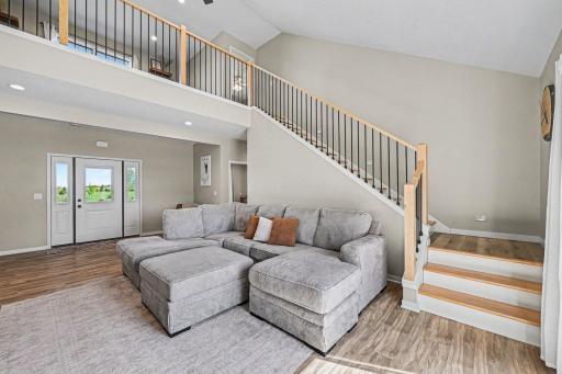 Living room view toward lake-side windows and open staircase â 4-bedroom home in Le Center MN, Tri City United district